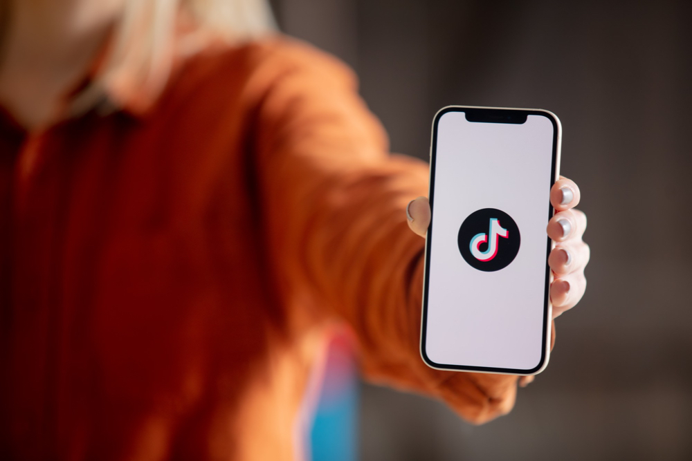 personne tenant un cellulaire avec le logo de tiktok