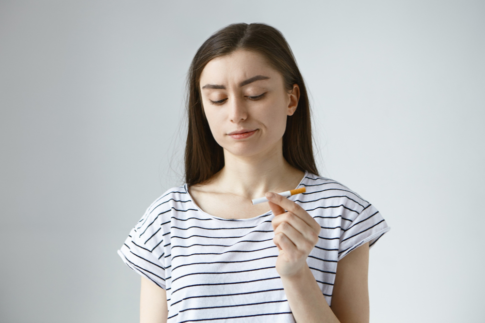 une femme avec une cigarette entre les doigts