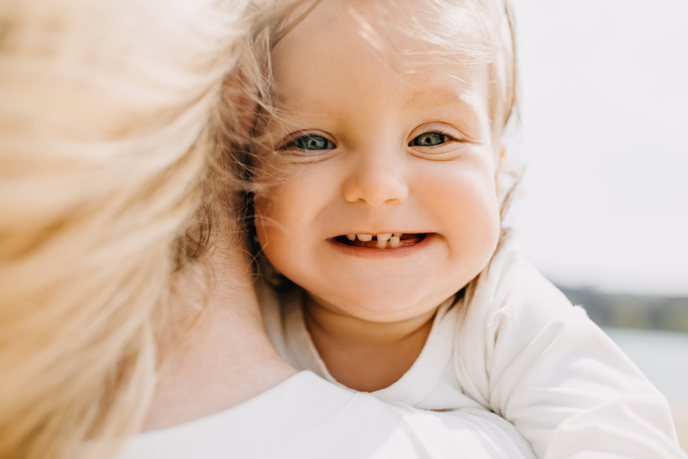 jeune fillette blonde d'un sourire manquant des dents de lait qui poussent encore