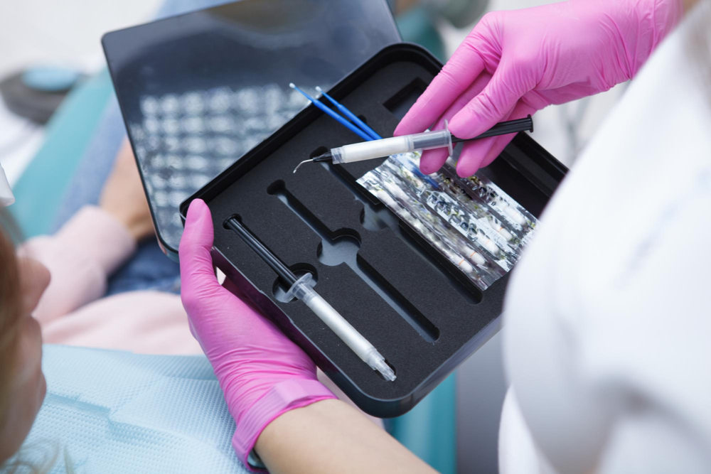 dentiste en tenant un plateau d'outils pour le traitement de blanchiment dentaire