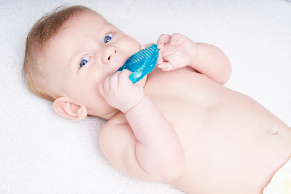 Bébé qui mâchouille un jouet en caoutchouc pour la poussée des dents