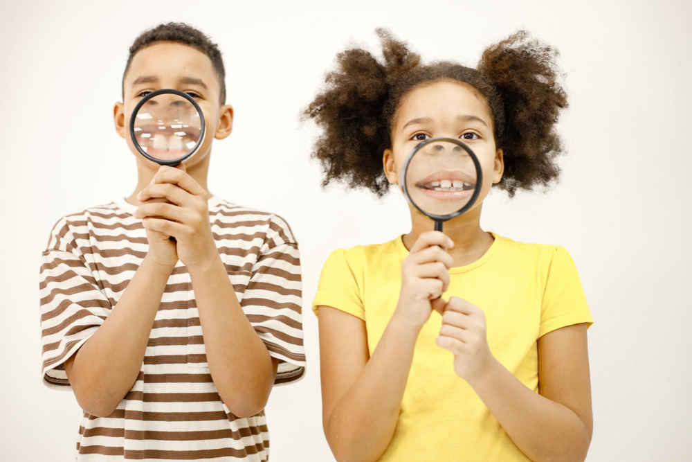 deux enfants garçon et fillette avec des loupes devant leur sourire à pleine dents blanches sur la rive sud de montréal