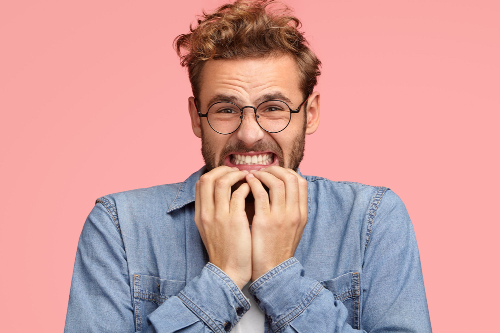 jeune homme à lunettes à boucherville est anxieux de la pandémie sur un fond rose