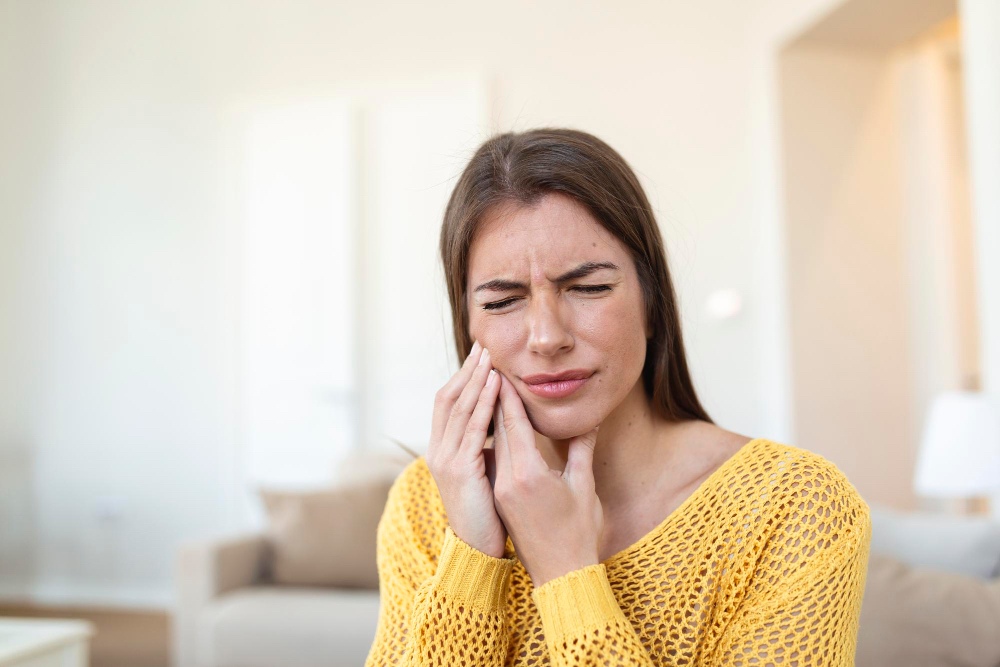 femme en douleur se tenant la bouche causée par maux de dents