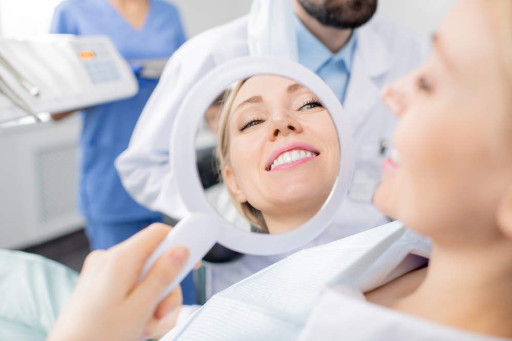 femme aux dents implants blanches se regardant dans le miroir souriante