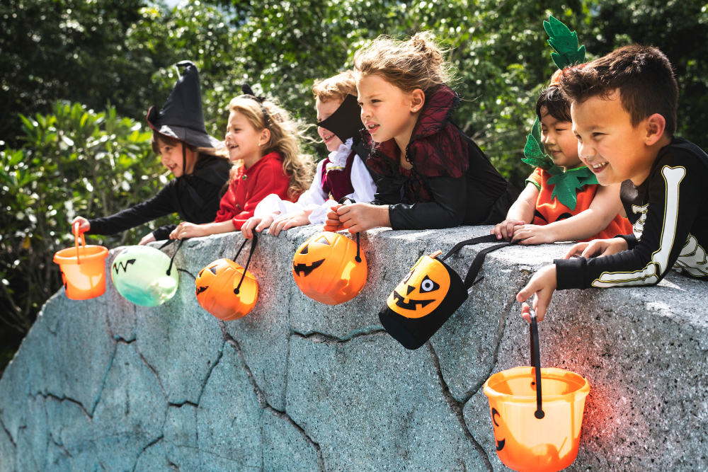 enfants déguisés en costumes avec sceaux remplis de bonbons après l'halloween